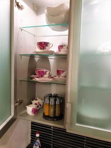 um armário cheio de pratos e copos cor-de-rosa em Ferienwohnung Royal Walchensee em Walchensee
