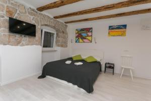 a bedroom with a bed with a tv on the wall at Apartment Relax in Rijeka