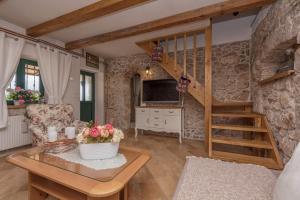 a living room with a staircase in a stone wall at Holiday home Stipanovi Dvori with jacuzzi and pool in Zagvozd