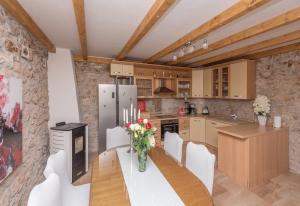 a kitchen with a table with a vase of flowers on it at Holiday home Stipanovi Dvori with jacuzzi and pool in Zagvozd