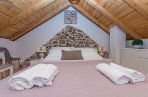 a bedroom with a large bed with towels on it at Holiday home Stipanovi Dvori with jacuzzi and pool in Zagvozd +42 photos