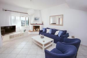 a living room with a blue couch and a tv at Hilltop Holiday Residence in Corfu Town