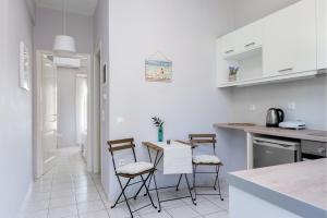 a white kitchen with a table and chairs at Hilltop Holiday Residence in Corfu Town