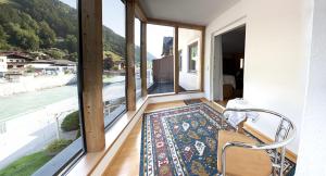 Zimmer mit großen Fenstern und einem Teppich auf dem Boden in der Unterkunft Gredler in Zell am Ziller