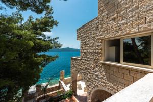 a stone house with a view of the water at Beach Villa Ratac in Slano