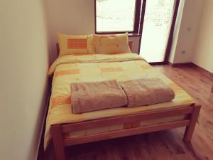 a small bed in a room with a wooden floor at Sobe Gmitrovic in Rtanj