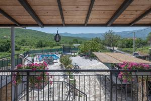a balcony with a view of a pool and flowers at Holiday home Stipanovi Dvori with jacuzzi and pool in Zagvozd