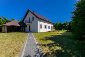 una casa blanca con un camino de ladrillo delante de ella en Pokoje gościnne, nowy dom, cisza i spokój, Władysławowo, en Władysławowo