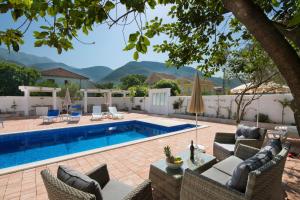 a swimming pool with chairs and a table next to a pool at Luxurious Apartments Aria in Budva