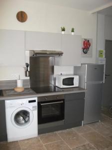 uma cozinha com uma máquina de lavar roupa e um micro-ondas em ST REMY DE PROVENCE PROCHE CENTRE VILLE - Parking privé em Saint-Rémy-de-Provence