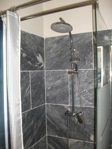 La salle de bains est pourvue d'une douche et d'un mur carrelé noir. dans l'établissement ST REMY DE PROVENCE PROCHE CENTRE VILLE - Parking privé, à Saint-Rémy-de-Provence