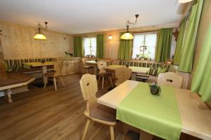 ein Restaurant mit grünen Vorhängen, Tischen und Stühlen in der Unterkunft Haus Bödele in Sankt Leonhard im Pitztal