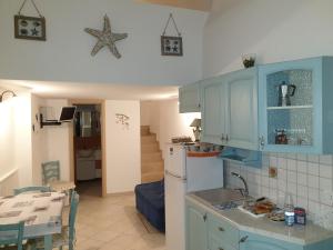 a kitchen with blue cabinets and a table and a dining room at Lo scrigno dei sogni in Polignano a Mare