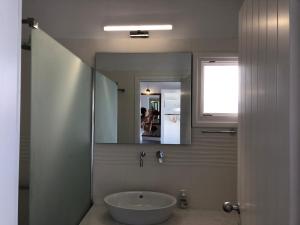 a bathroom with a sink and a mirror at Villa Gambas Beach Studios in Kamari