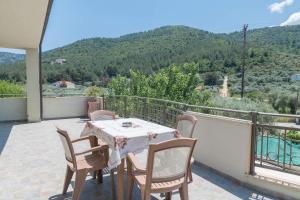 a table and chairs on a balcony with a view at Geka's apartment in Skala Rachoniou