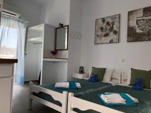 a bedroom with a bed, desk and a painting on the wall at Villa Gambas Beach Studios in Kamari