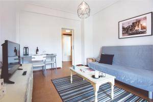 een woonkamer met een blauwe bank en een tafel bij Comfy & Relaxing Apartment in Thessaloniki