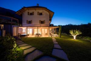 une grande maison blanche avec une cour en herbe dans l'établissement SOFTALPIN Garden Suites, à Appiano sulla Strada del Vino