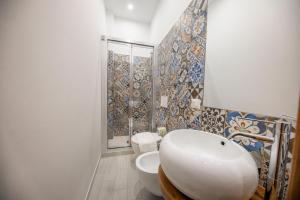 a white bathroom with a sink and a toilet at Hortensia House in Cefalù