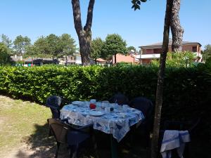 a table with plates and glasses on top at Adriella apartments in Bibione