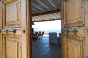 an open door to a patio with a table and chairs at Elia Horizon Mykonos in Elia Beach