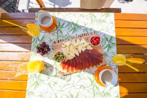 una mesa con un plato de queso y fruta. en Villa Sandra en Petrovac na Moru