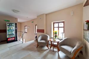 a waiting room with two chairs and a table at Apartamenty Pod Lwem in Świdnica