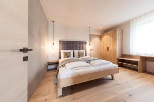 - une chambre avec un grand lit dans l'établissement SOFTALPIN Garden Suites, à Appiano sulla Strada del Vino