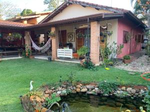 a house with a pond in front of it at Refugio de Paz in São Pedro