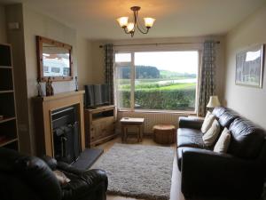 a living room with a couch and a fireplace and a window at River View in Coleraine