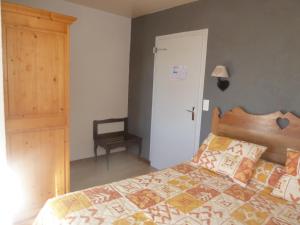 Schlafzimmer mit einem Bett mit einem Kopfteil aus Holz in der Unterkunft Auberge Le Sillet in Longcochon
