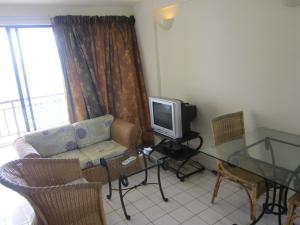 a living room with a couch and a tv at Paradise Lagoon Apartment in Port Dickson