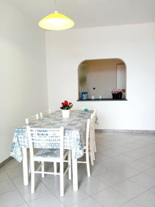 a dining room table with white chairs and a mirror at Georgia House in Torre Suda +7 photos