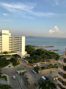 a large building with a parking lot next to the ocean at Ocean blue Ed Conquistador in Cartagena de Indias