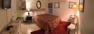 a bedroom with a bed with a red bedspread at The Tilton Inn in Tilton