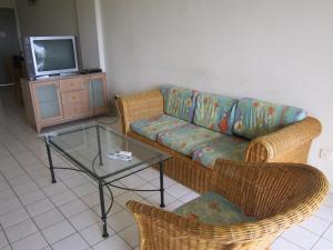 a living room with a couch and a glass table at Paradise Lagoon Apartment in Port Dickson