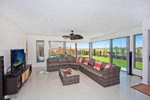 a living room with a couch and a tv at Casuarina Beach House by Kingscliff Accommodation in Kingscliff