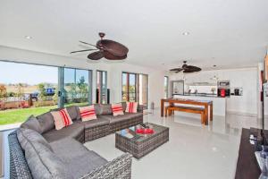 a living room with a couch and a piano at Casuarina Beach House by Kingscliff Accommodation in Kingscliff