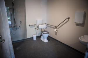 a white toilet sitting in a bathroom next to a sink at Cadell On The Murray Motel in Moama