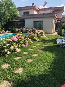 a house with a yard with flowers and a swimming pool at Villa Onuk in Sapanca