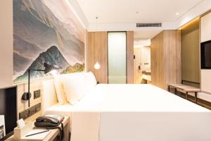 Säng eller sängar i ett rum på Atour Hotel Changxing Central Plaza