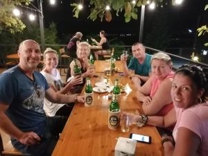 un grupo de personas sentadas alrededor de una mesa bebiendo cerveza en Lam-tong Resort, en Don Sak