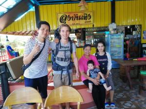 a family posing for a picture in front of a store at Lam-tong Resort in Don Sak