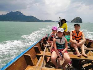un grupo de personas sentadas en un barco en el agua en Lam-tong Resort, en Don Sak
