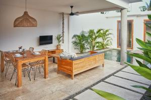 sala de estar con mesa y bañera en Kumbara Villas en Kuta Lombok