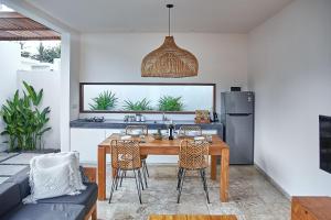 a kitchen and dining room with a table and chairs at Kumbara Villas in Kuta Lombok