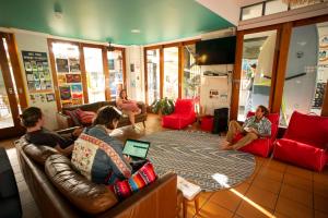 un grupo de personas sentadas en una sala de estar en YHA Cape Byron, Byron Bay en Byron Bay