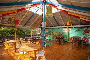 a restaurant with tables and chairs and a colorful wall at YHA Cape Byron, Byron Bay in Byron Bay