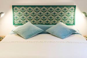 Una cama con dos almohadas encima. en CASADELCORSO NOGI en Sarteano
