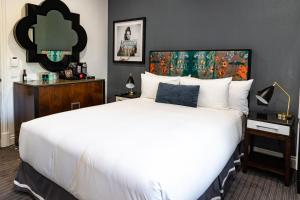 um quarto com uma cama branca e um quadro na parede em The Inchcolm em Brisbane